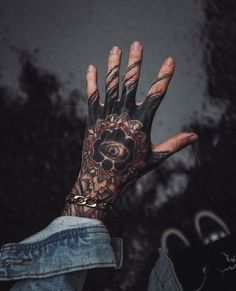 a person with tattoos on their hand holding something in the air