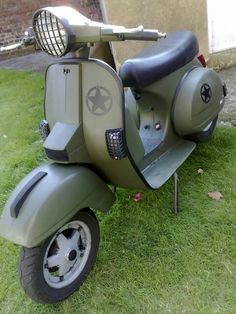 an old scooter is parked in the grass