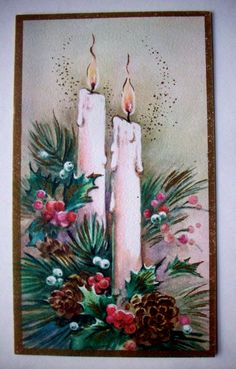 two lit candles surrounded by holly and pine cones