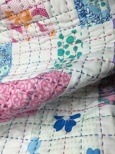 a close up view of a quilt with flowers and butterflies on the fabric, as if it were made from an old piece of cloth