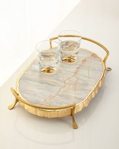 a tray with two glasses on it sitting on top of a white tablecloth covered floor