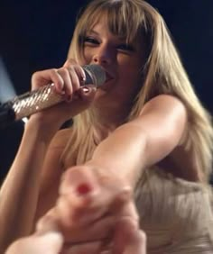 a woman holding a microphone up to her mouth