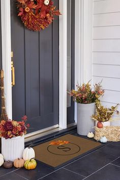 the front door is decorated with fall decorations