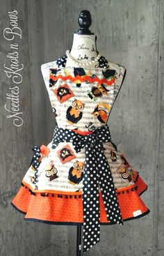 the apron is decorated with black and white polka dots, orange trims, and bears