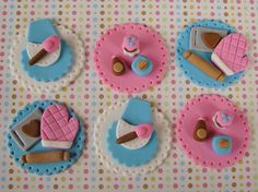 four decorated cookies sitting on top of a pink and blue table cloth covered in icing