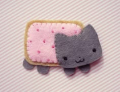 a close up of a piece of felt with a cat on it's side