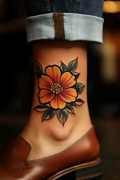 a woman's foot with a flower tattoo on the side of her leg,