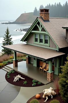 a house with a porch and landscaping in front of the ocean