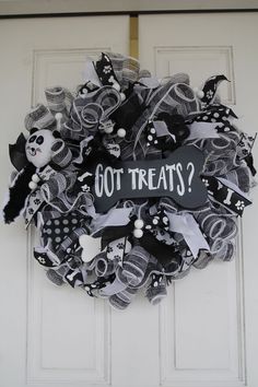 a black and white wreath with the words got treats written on it in front of a door