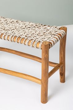 a wooden bench with woven seat cushion