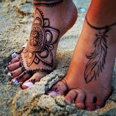 a woman's feet with hennap on the beach