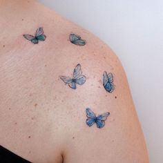 a woman's shoulder with blue butterflies on the back of her arm and chest