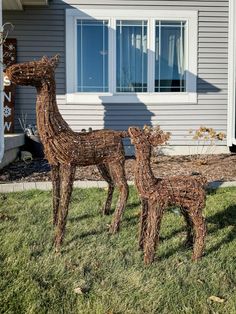 two wooden deer sculptures in front of a house