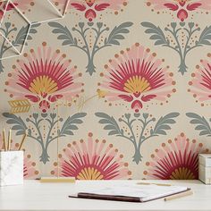 a desk with a book, vase and clock on it next to a wallpaper