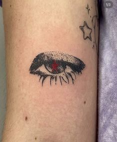 a close up of a person's arm with an eye and stars on it