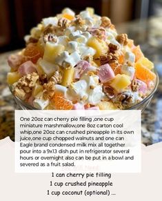 a bowl filled with fruit and nuts sitting on top of a counter next to a recipe