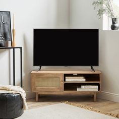 a flat screen tv sitting on top of a wooden entertainment center in a living room