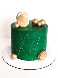 a green cake with gold decorations on top