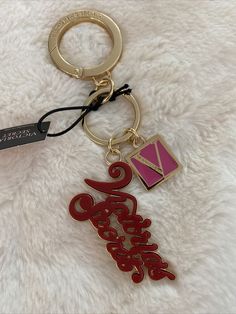 a red and black keychain with a name tag attached to it on a white furnishing