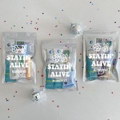 three bags of toothpaste sitting on top of a table with confetti