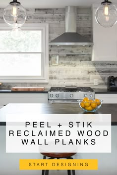 a kitchen with white cabinets and wood planks on the walls, along with a bowl of fruit