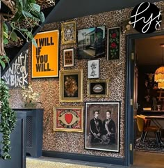 the entrance to a restaurant with pictures and paintings on the wall above it, along with plants