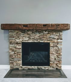 a stone fireplace in a room with white walls