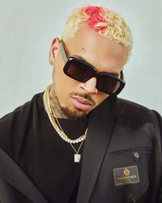 a man with pink hair wearing sunglasses and a black jacket