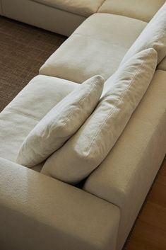 a large white couch with two pillows on it's back and the arms folded up