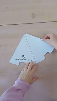 someone cutting out a paper origami christmas tree