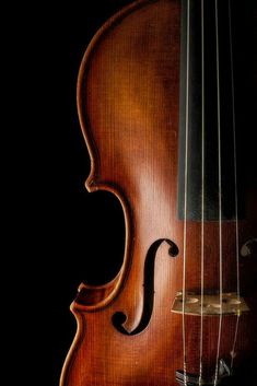 an old violin on a black background with the strings still attached to it's back