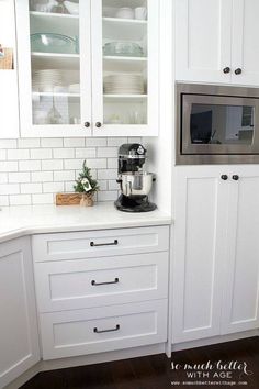 a kitchen with white cabinets and stainless steel appliance on the counter top next to an oven