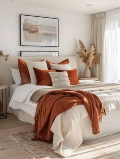 a bed with orange and white pillows in a bedroom