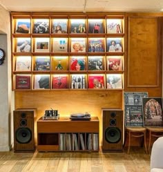 a room with speakers, bookshelves and pictures on the wall