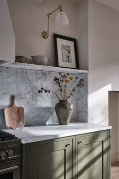 a vase with flowers is sitting on the counter in this modern kitchen, while an oven and sink are also visible