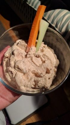 a person is holding a bowl with food in it and carrot sticks sticking out of the top