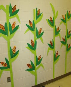 the wall is decorated with paper cut outs and painted green leaves, which are arranged on top of each other