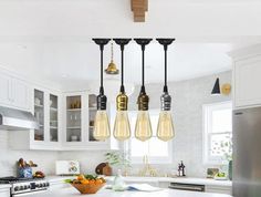 a kitchen with several lights hanging from the ceiling