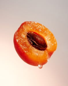 an orange with water droplets on it sitting in front of a white background that appears to be half eaten