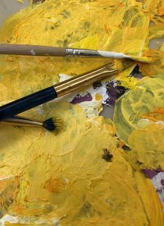 the paint is yellow and there are two brushes