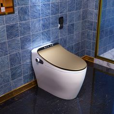 a white toilet sitting next to a blue tiled wall