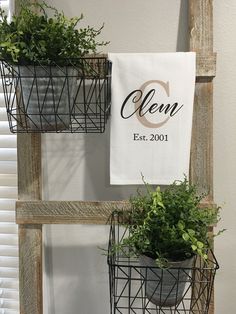 two metal baskets with plants in them are hanging on the wall