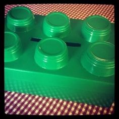 four green plastic cups sitting on top of a table