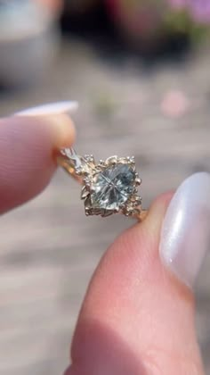 a person holding a ring with a diamond in it