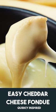 a ladle full of melted cheese being held by a wooden spoon in a black bowl