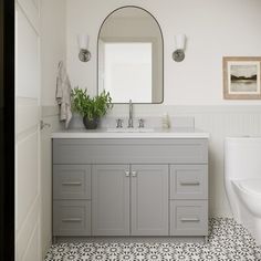 a bathroom with a sink, mirror and toilet