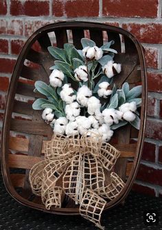 a bunch of flowers sitting on top of a wooden chair next to a brick wall