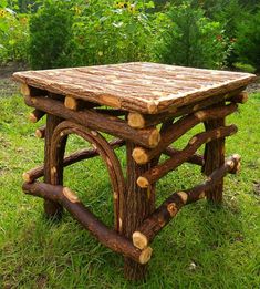 a table made out of logs in the grass