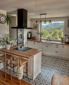 a kitchen with an island counter and stools in front of the stove top oven