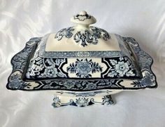 an ornate blue and white serving dish on a white tablecloth with a black border